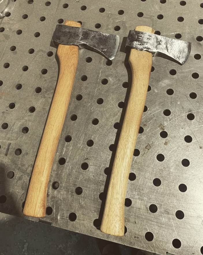 Two finished hand forged axes on the workbench